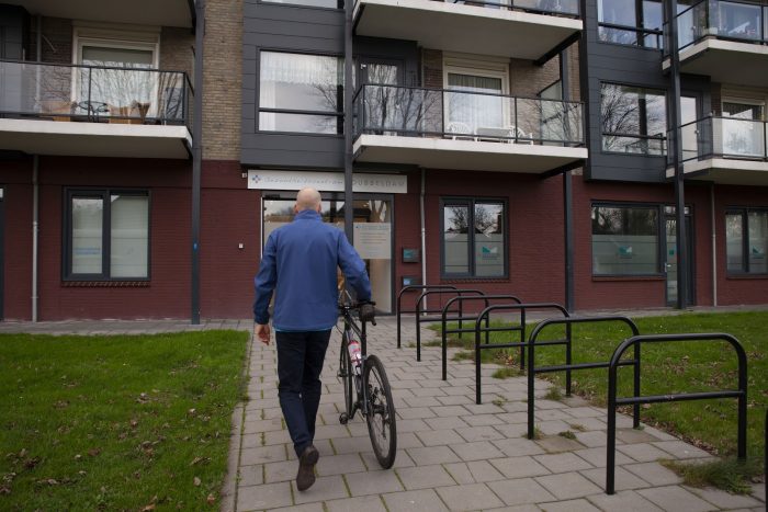 Positieve effecten van fietsen Man loopt met de fiets aan de hand over de positieve effecten van fietsen