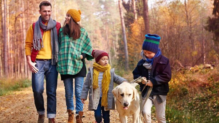 Herfstdip voorkomen Een gezin is buiten aan het wandelen om een herfstdip te voorkomen