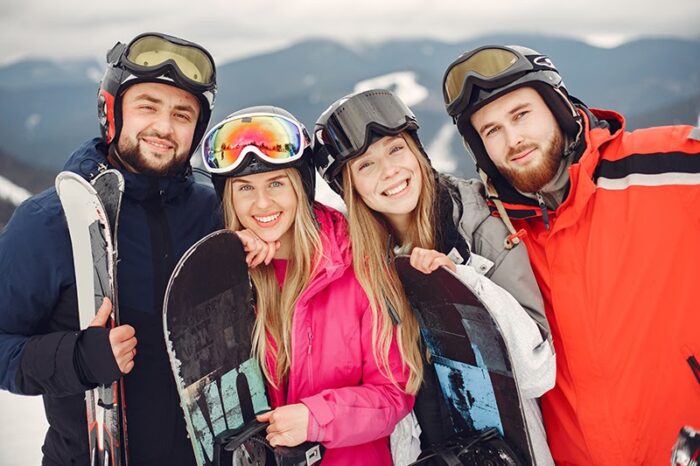 Kerstactiviteiten 4 mensen zijn bezig met wintersporten voor gezonde en actieve kerstactiviteiten