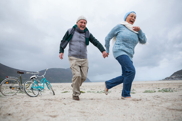 Reuma 2 mensen lopen over het strand en hebben last van reuma