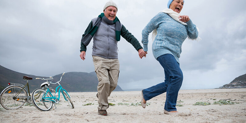 2 mensen lopen over het strand en hebben last van reuma