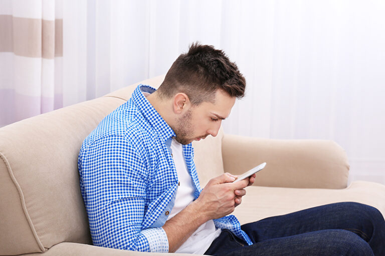 Man heeft last van nekpijn door het gebruik van zijn smartphone