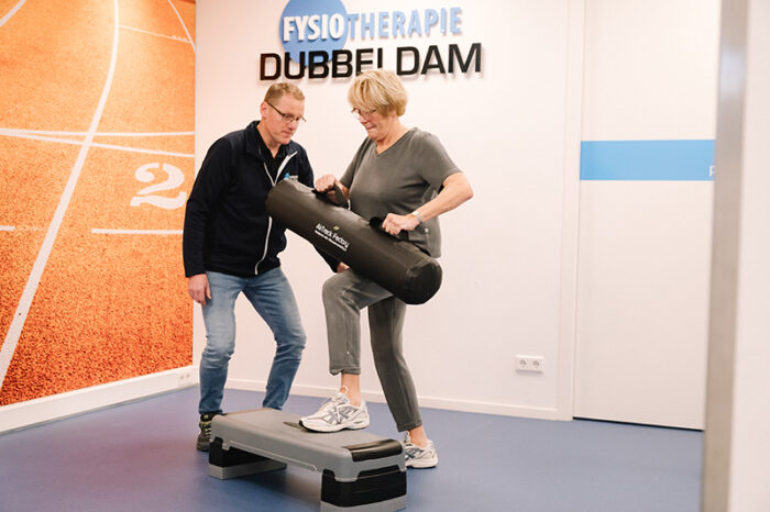 Fysiotherapie bij knieklachten Vrouw in sportkleding traint bij de fysiotherapeut in de oefenzaal voor fysiotherapie bij knieklachten en krijgt knie-revalidatie