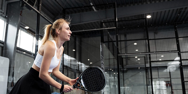 Vrouw heeft een tenniselleboog bij padellen