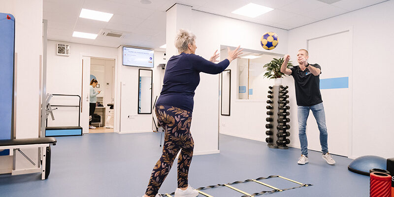 Vrouw in haar pensioen blijft fit door te sporten tijdens fysiotherapie