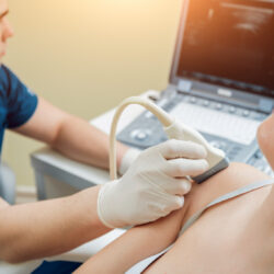 Fysiotherapeut gebruikt echografie om de pijn in de schouder van een patiënt te achterhalen