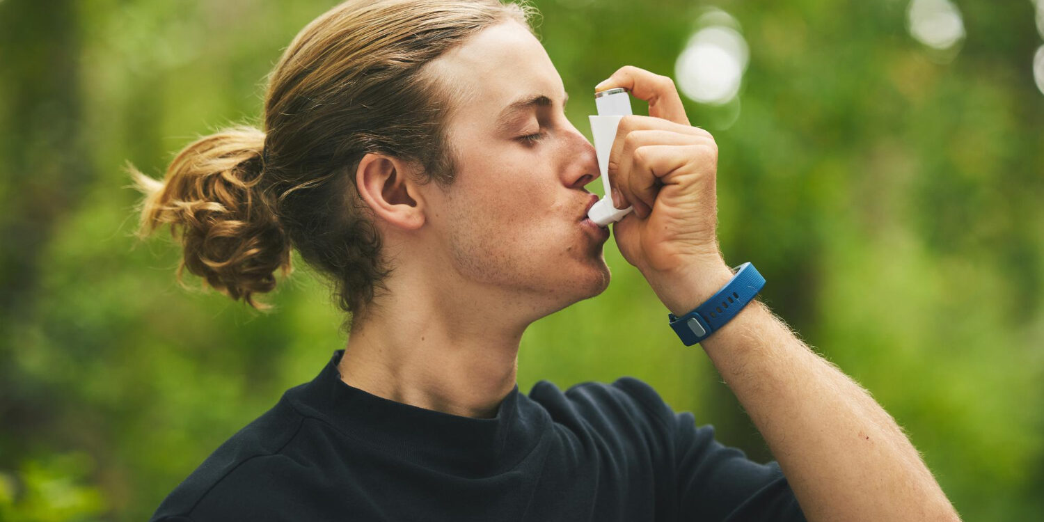 Man met een manbun heeft Astma en gebruikt een puffer.