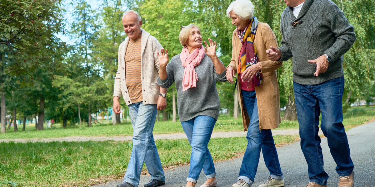 Groepje ouderen is buiten aan het wandelen terwijl ze met elkaar in gesprek zijn