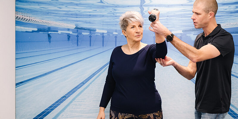 Vrouw doet oefeningen omdat ze polsklachten heeft door smartphone gebruik.