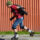Man in rood t-shirt is aan het skeeleren met heel veel bescherming aan. Dit doet hij, omdat hij veel last had van blessures door het skeeleren.